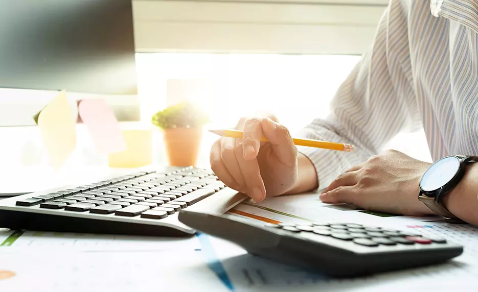 person using a calculator at a desk